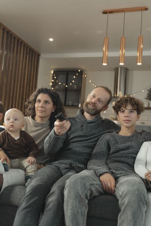 Famille sur canapé regardant la TV — abonnement IPTV SmartX2 France chaînes françaises algériennes marocaines